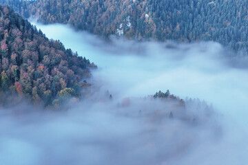 Magnificent landscapes of autumn mountains covered with fog, reaching the distant snow-capped peaks of the High Tatras
