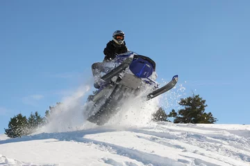 Fotobehang extreme snowmobile rider jumping machine through powder in mountains © Nathan Allred