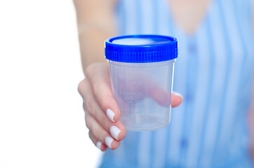 Woman holding container for urine analysis in hand on white background isolation