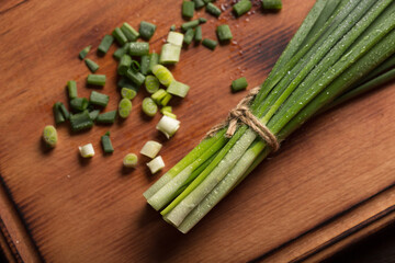 Chives feathers chopped on a board, top view