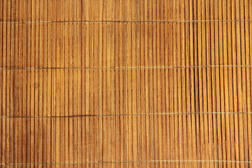 Brown bamboo food mat taken closeup as background.