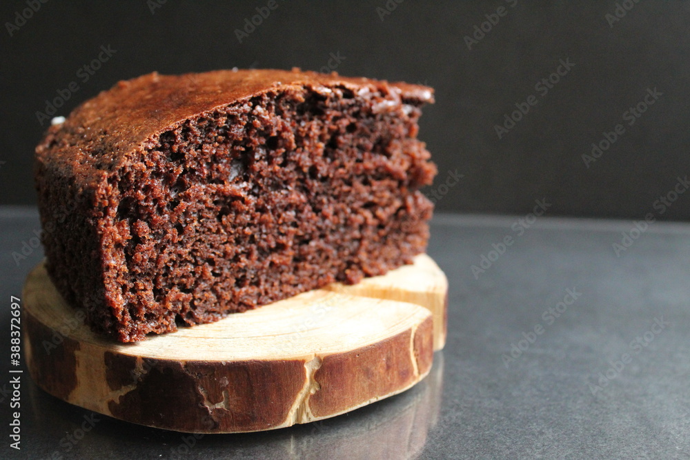 Wall mural chocolate brownie pie on a wooden backing stand in a black place with copy space for text