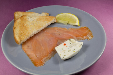 Plate of smoked salmon and vegetables terrine with toasted bread and lemon