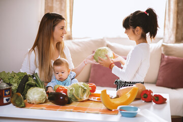 Young mother and children preparing meal with healthy food