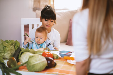 Young mother and children preparing meal with healthy food