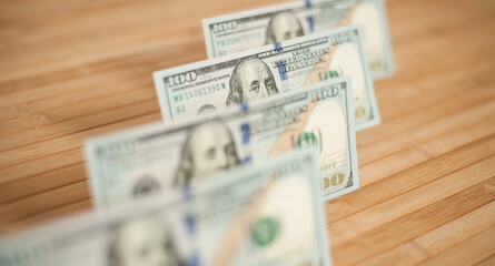 100 Dollars bill and portrait Benjamin Franklin on USA money banknote. Hundred dollar bills on wooden background..