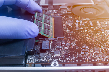 Service engineer install new RAM memory chips to the laptop. Repairing and upgrading laptop...