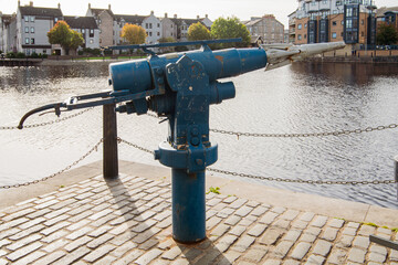 An old harpoon gun from a Christian Salvesen Company whaling ship, now mounted by a pathway at the mouth of the Water of Leith in Edinburgh, Scotland, UK.  Near the old Victoria Swing Bridge. - 388378633