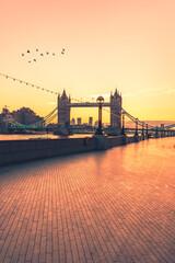 Morning sunrise at Tower Bridge, birds are crossing the way, London