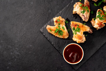 grilled chicken wings with sauce on stone background. selective focus with copy space for your text