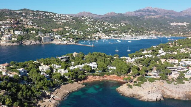 Port Andratx in Mallorca Spain with resorts, boats and homes by Marmassen Cove, Aerial dolly right wide shot