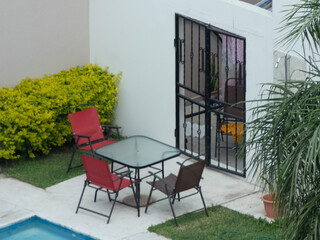 Patio trasero natural con piscina y juego de jardin 