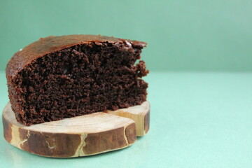 chocolate brownie pie on a wooden backing stand on a green grass background with copy space for text