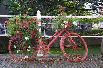 Fototapeta na wymiar Old-fashioned city bike near a bridge over canal in the Old Town of Delft, Holland