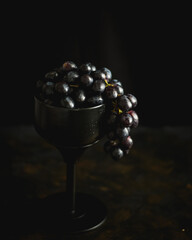 Red grapes in a goblet on a dark background