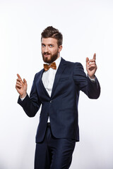 Elegant young handsome man in black classic costume. Studio fashion portrait. Isolated on white.