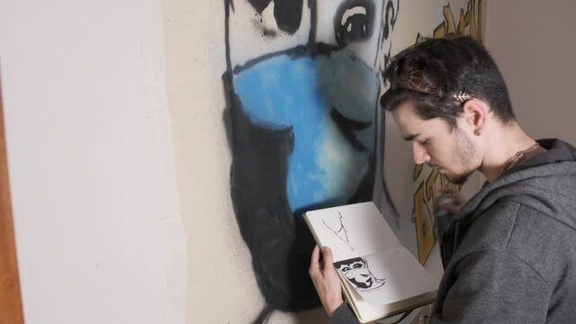 Young artist launching a graffiti message to raise awareness about keeping social distancing, prevention and use of the mask to combat the transmission of the coronavirus COVID19