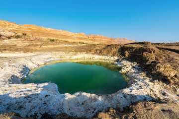 Fototapeta na wymiar A small salt lake on the shores of the Dead Sea, the lowest point on earth on land, near Ein Gedi. Israel 