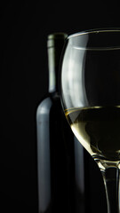 wine bottle and glass, black background
