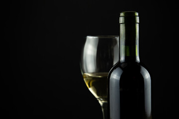 wine bottle and glass, black background
