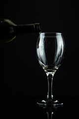 wine bottle and glass, black background

