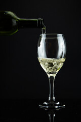 wine bottle and glass, black background
