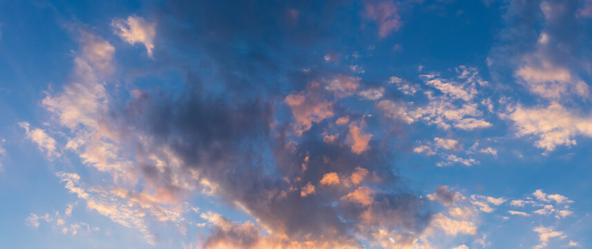 cloudscape in late day sky, golden sunlight reflecting in nuves