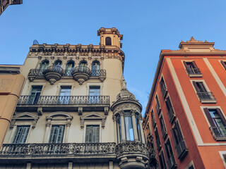 Facade of buildings in the center of the Spanish city of Barcelona. The building is gray and orange...