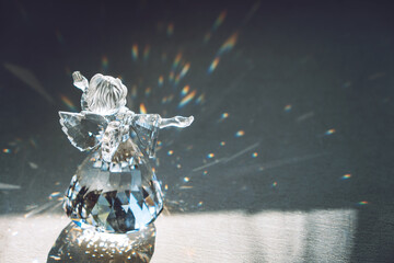 Crystal glass angel in the rays of the sun with reflecting, embossed sparkle. Faith, hope, mercy...