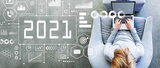 2021 New Year concept with man using a laptop in a modern gray chair