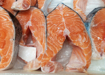 Steaks of fresh salmon red fish on the store counter in ice