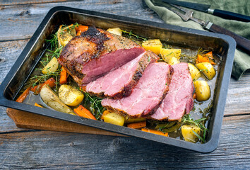 Traditioneller Surbraten vom Schwein aufgeschnitten und angeboten mit Kartoffel, Karotten und...