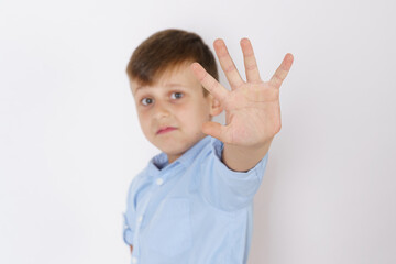 The boy expresses his emotions by putting forward his open palm. Isolated over white background.