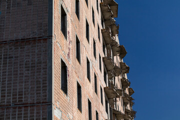 High multistorey abandoned soviet building facade with crashed balconies. Weathered house on sunny...