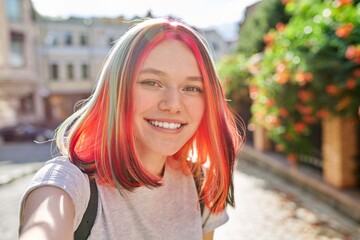 Teenager girl with trendy hairstyle, young fashion art blogger records stream in city