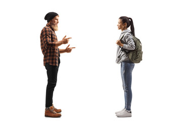 Full length profile shot of a bearded guy standing and talking to a young female student
