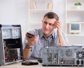 Young technician repairing computer in workshop