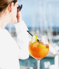 Woman with a glass of aperol spritz cocktail
