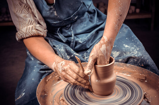 hands of potter do a clay pot