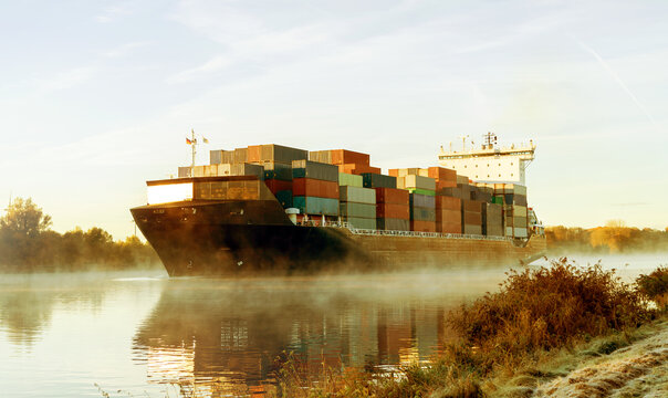 Nord-Ostsee-Kanal in Schleswig-Holstein,  Sonnenaufgang mit Containerschiff im Nebel 
