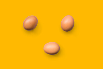 fresh brown organic chicken eggs isolated on yellow background. Horizontal composition. Top view