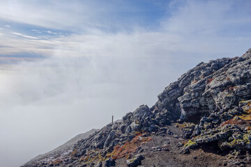 A view from the side of Mount Pico on Pico Island in the Azores, while climbing to the top on a bright sunny day with interesting cloud formations.