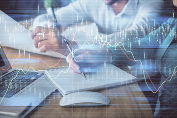 Double exposure of forex chart drawing over people taking notes background. Concept of financial analysis