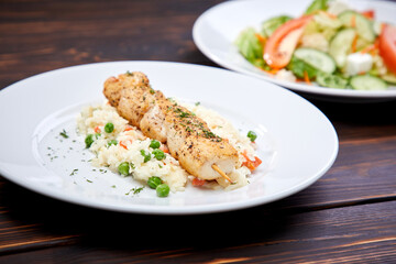chicken kebab with rice and vegetables on the wooden background