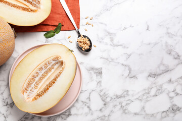 Delicious honey melon on white marble table, flat lay. Space for text