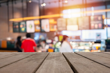 Wood table top background with blurred coffee shop and people sit on table blur background with bokeh image