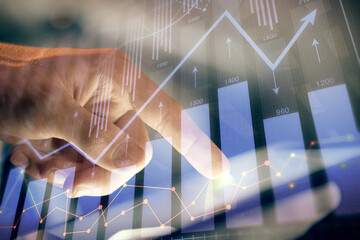 Multi exposure of man's hands holding and using a phone and financial chart drawing. Market...