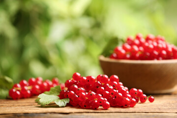 Ripe red currants on wooden table against blurred background. Space for text