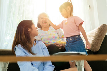 Obraz premium Asian niece and grandma are enjoying in their living rooms in their homes.