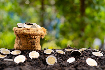 Financial business investment concept. A sack of bags filled with coins filled out on the mound